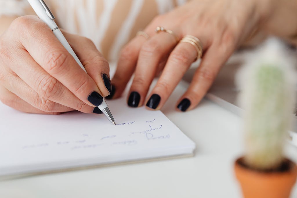 A detailed photo of hands writing on paper with a pen. Perfect for education and creativity themes.
